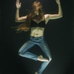 woman wearing black bra and blue denim jeans underwater
