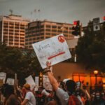 multiracial people with banners protesting on street in evening