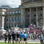 anonymous people protesting against old building in city