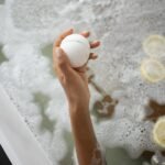 woman with ball of bath salt in bathtub