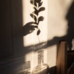 anonymous person putting plant into glass vase
